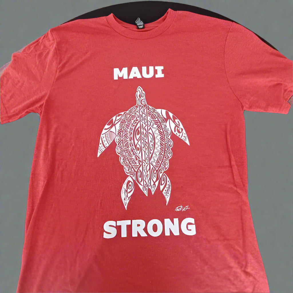 Red t-shirt with a turtle graphic and 'MAUI STRONG' text on a black surface.